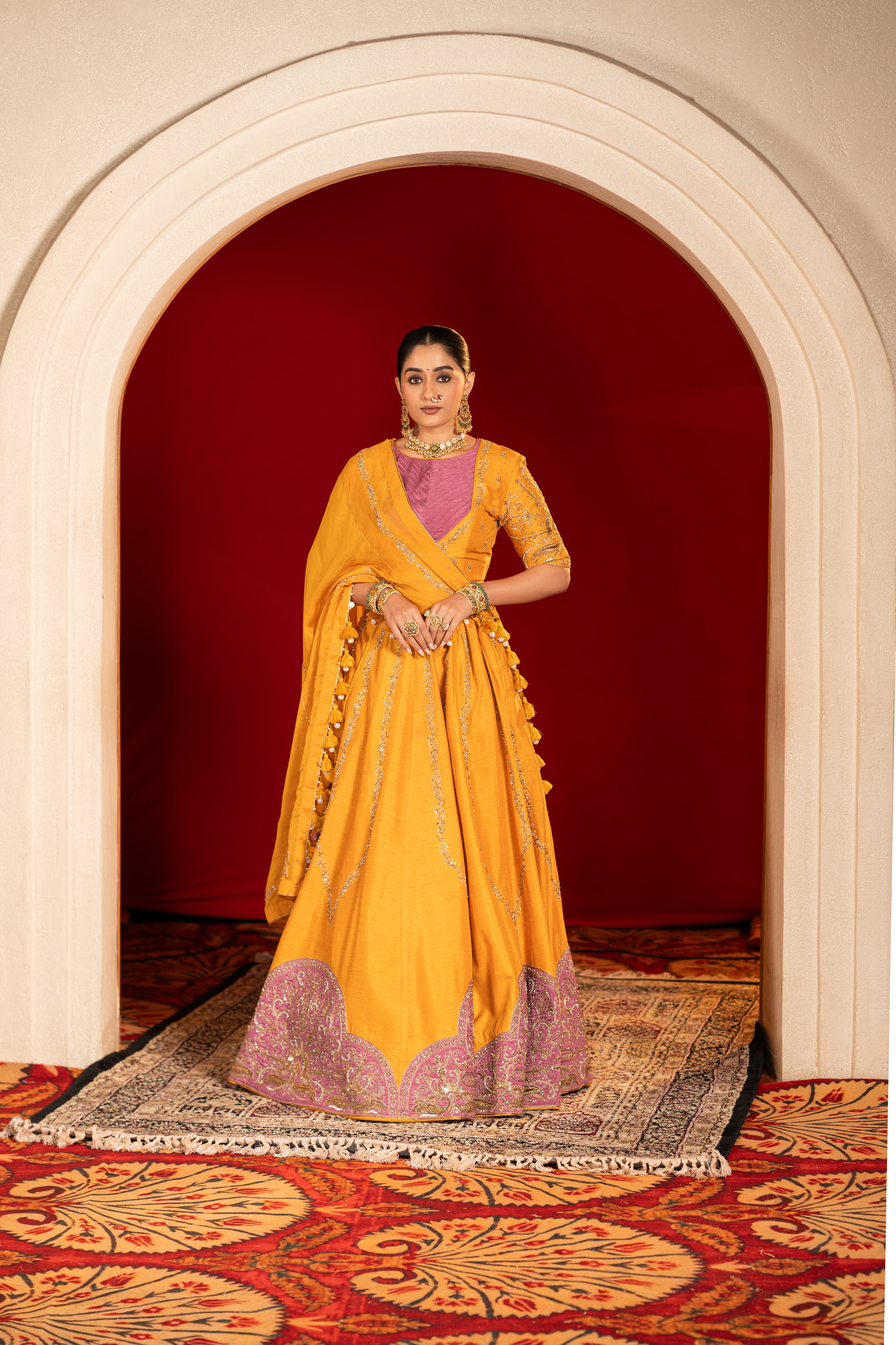 Mustard yellow lehenga with a mauve patch, paired with an organza dupatta and intricate handwork details.