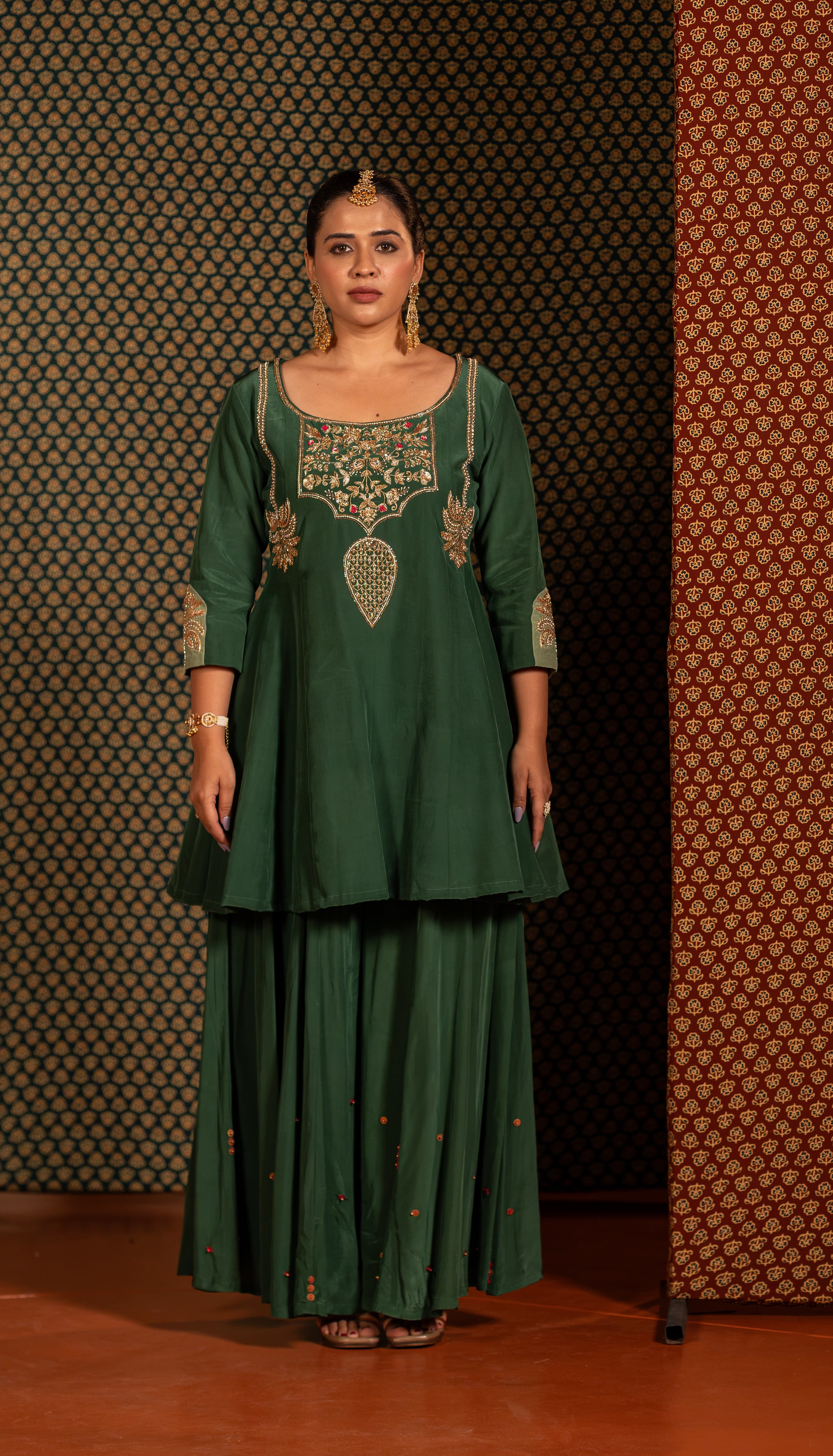 Dark green palazzo set adorned with coconut tree-inspired handwork motifs.