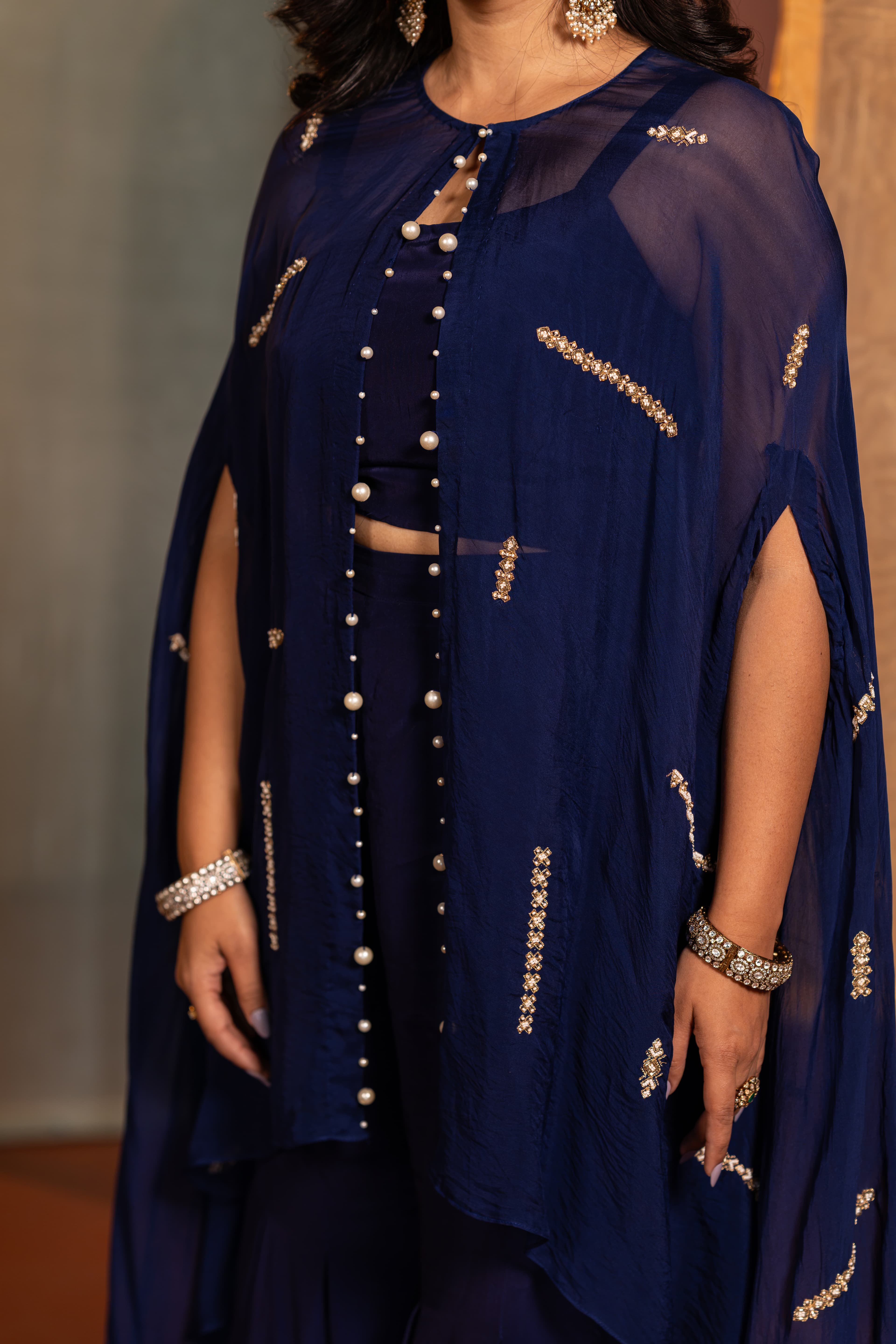 Craftsmanship detail — A contemporary navy-blue Indo Western set defined by sheer layer and refined handwork detail.